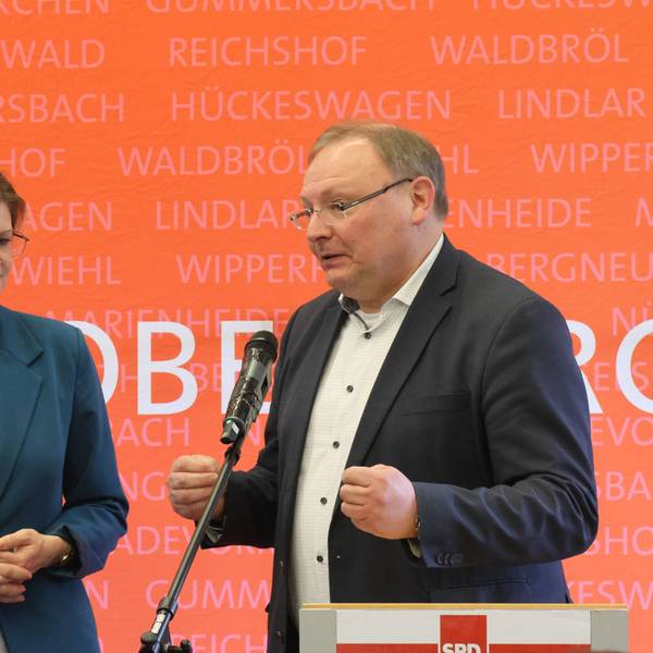 Eine Frau und ein Mann stehen zusammen am Rednerpult.