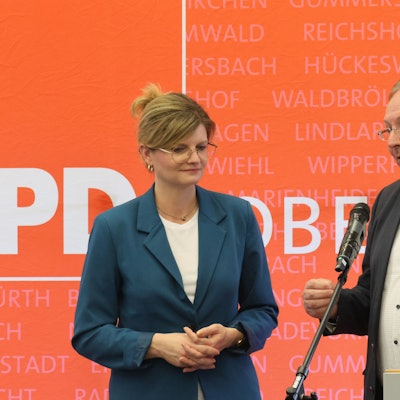 Eine Frau und ein Mann stehen zusammen am Rednerpult.