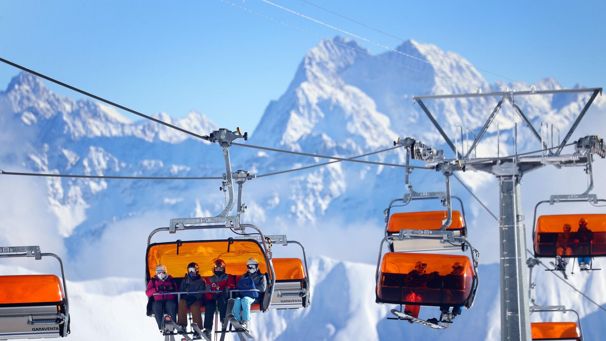 Skifahrer sitzen im Skigebiet Ischgl in einem Sessellift.
