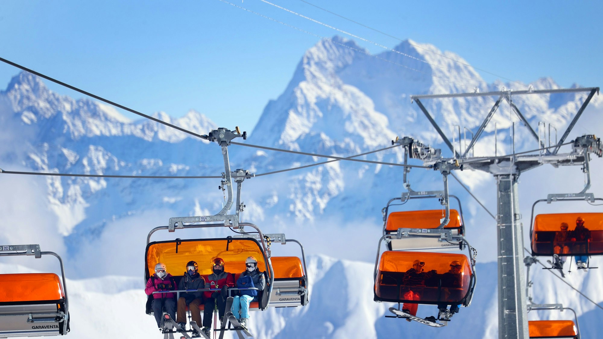 Skifahrer sitzen im Skigebiet Ischgl in einem Sessellift.