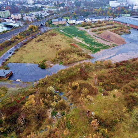 Das Bild zeigt das Areal der Steinzeugwerke aus der Luft. Es ist aktuell eine Brachfläche.