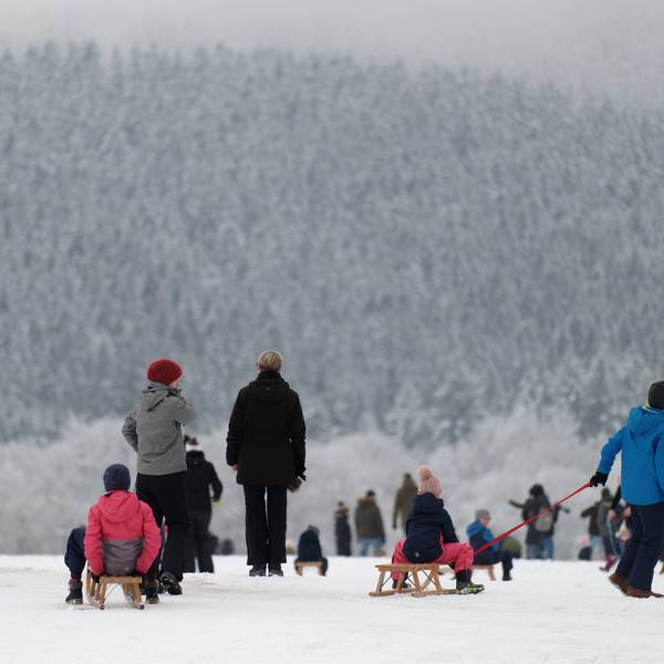 Spaziergänger und Rodelfreunde genießen das Winterwetter im Skigebiet „Weißer Stein“ in der Eifel.