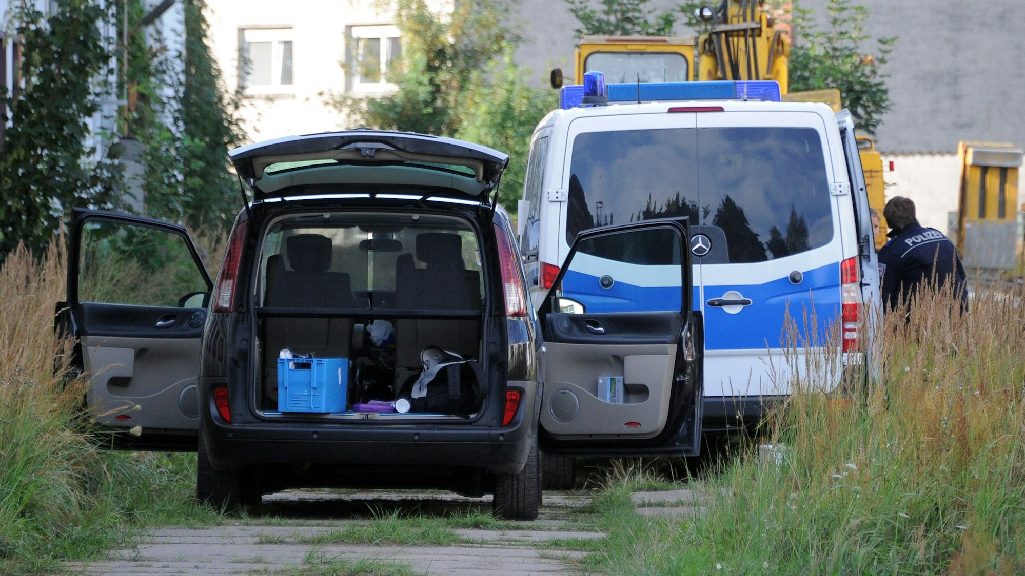 Polizeiwagen stehen vor einer Lagerhalle (Archivfoto).