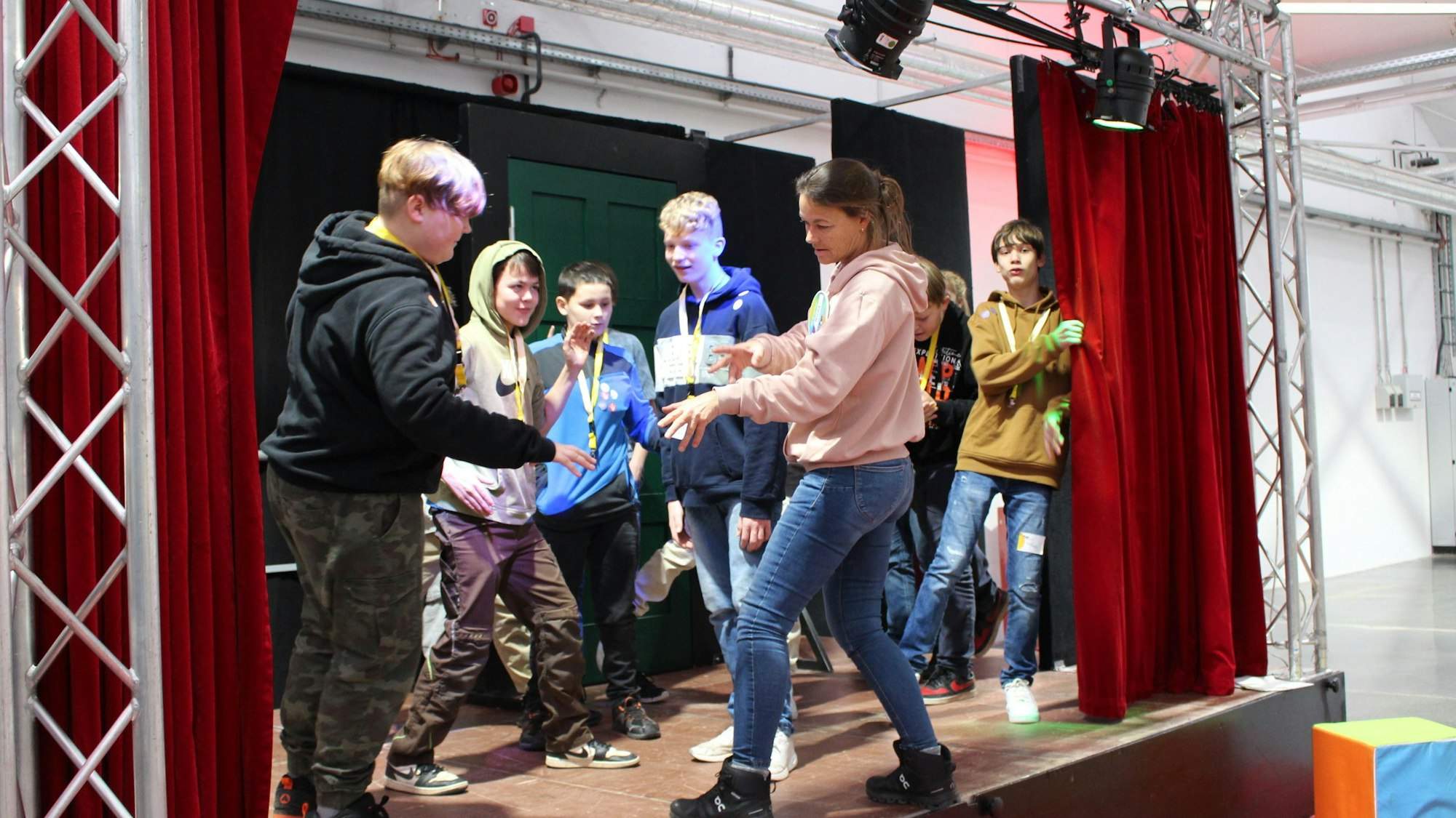 Mehrere Schüler bewegen sich auf einer Bühne.