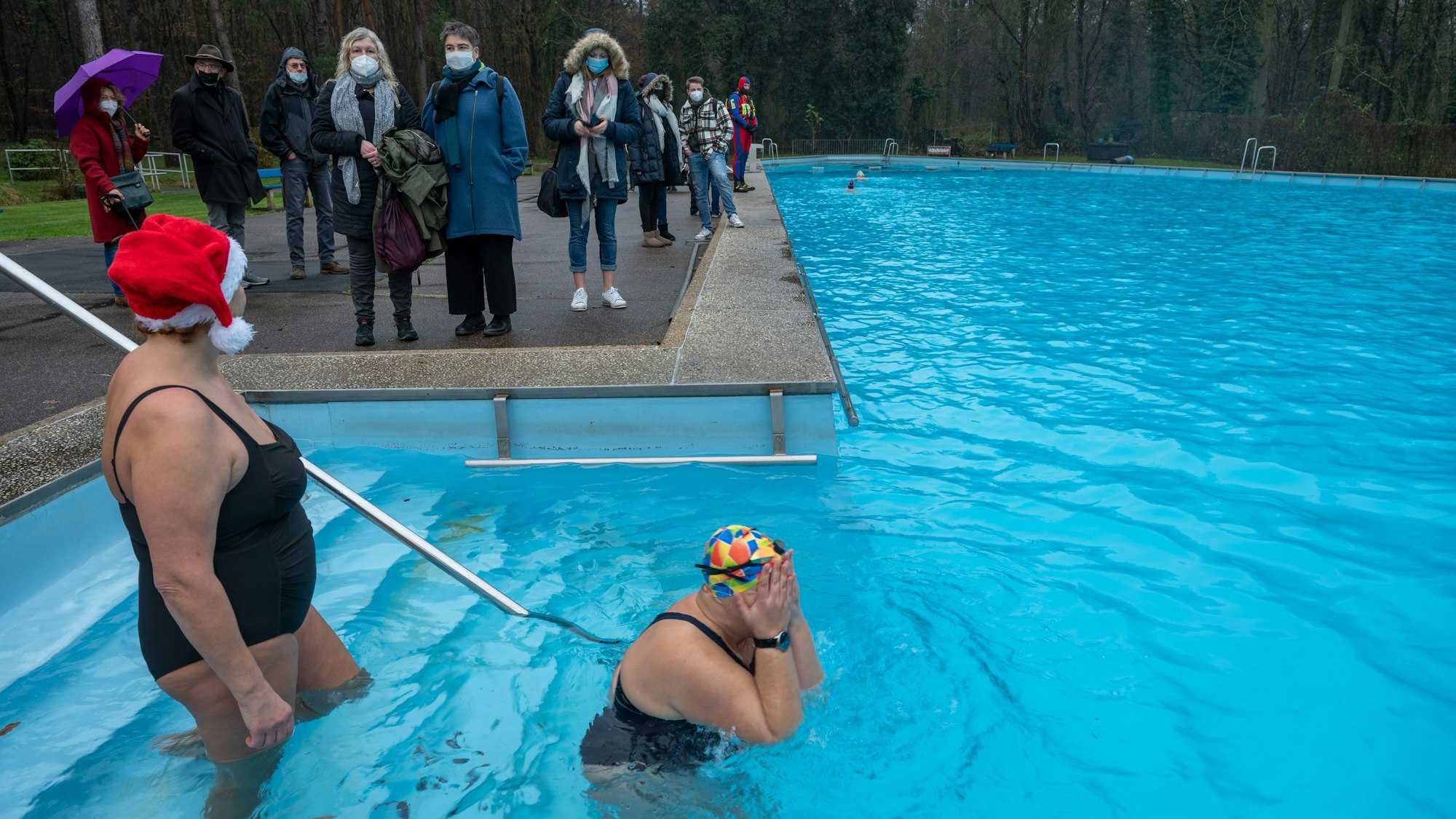 Schwimmerinnen gehen in ein Becken im Waldbad Dünnwald