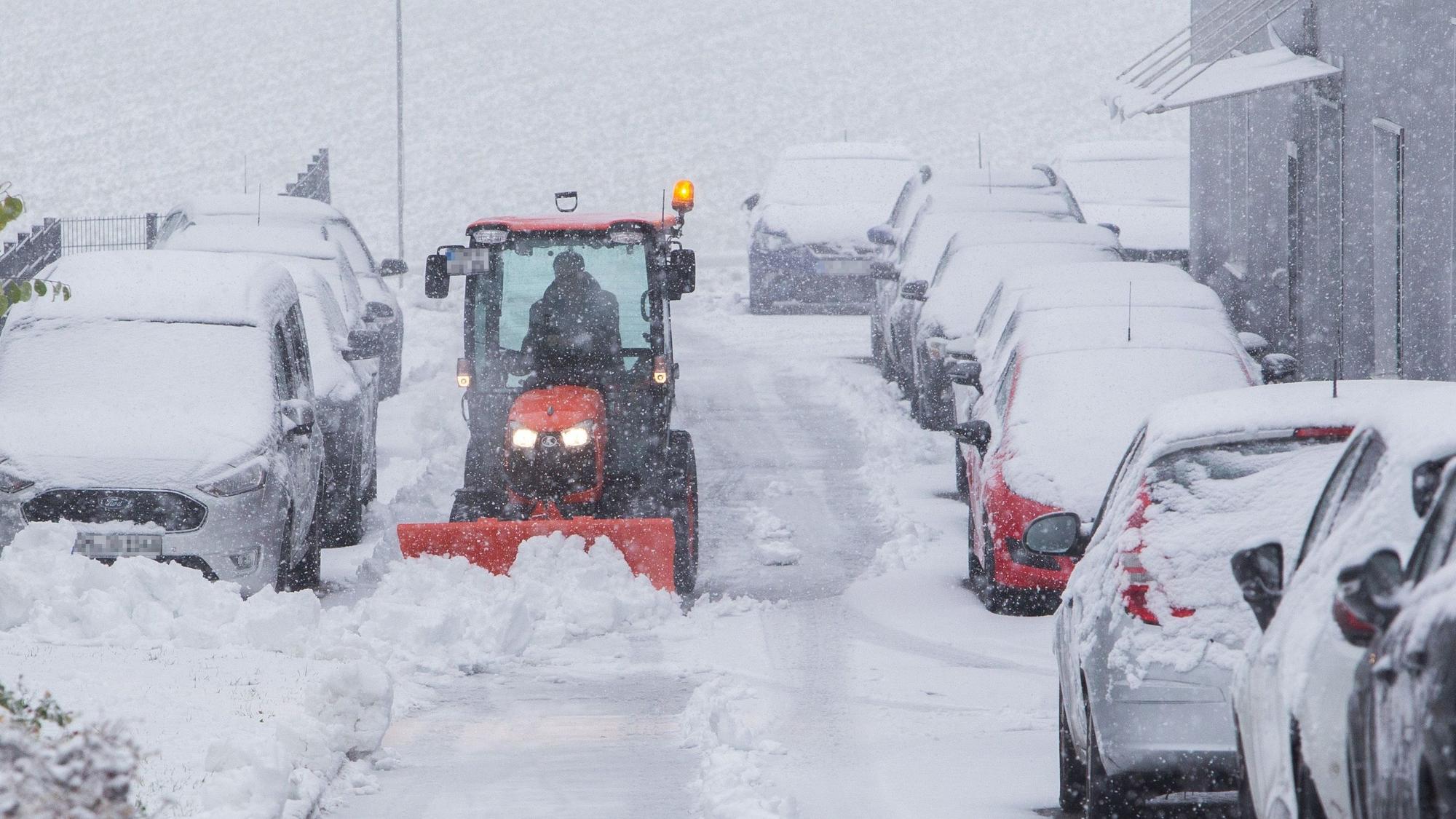Ein Schneeräumfahrzeug im Einsatz auf einer verschneiten Straße.