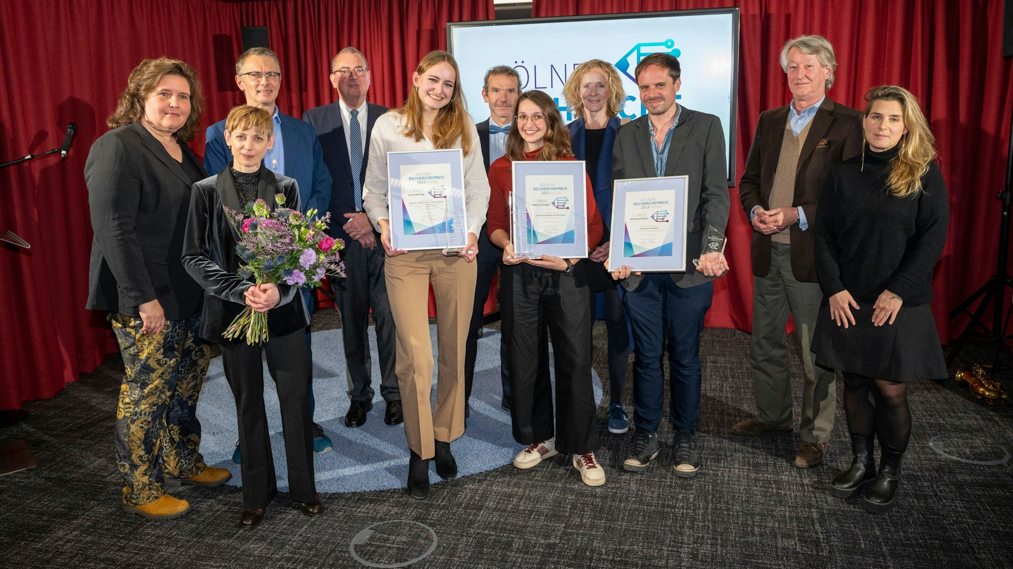 Die Preisträgerinnen und Preisträger: Lena Heising, Rebecca Singer und Andrew Müller (mit Urkunden, von links nach rechts), zusammen mit den Herausgebern des „Kölner Stadt-Anzeiger“, Christian DuMont Schütte und Isabella Neven DuMont (2. und 4. v.r.), Restrednerin Lara Fritzsche (SZ Magazin, r.) und Moderatorin Katharina Schmalenberg (Schauspiel Köln, 2.v.l.)
