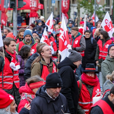 Streikende mit Fahnen in der Hand.