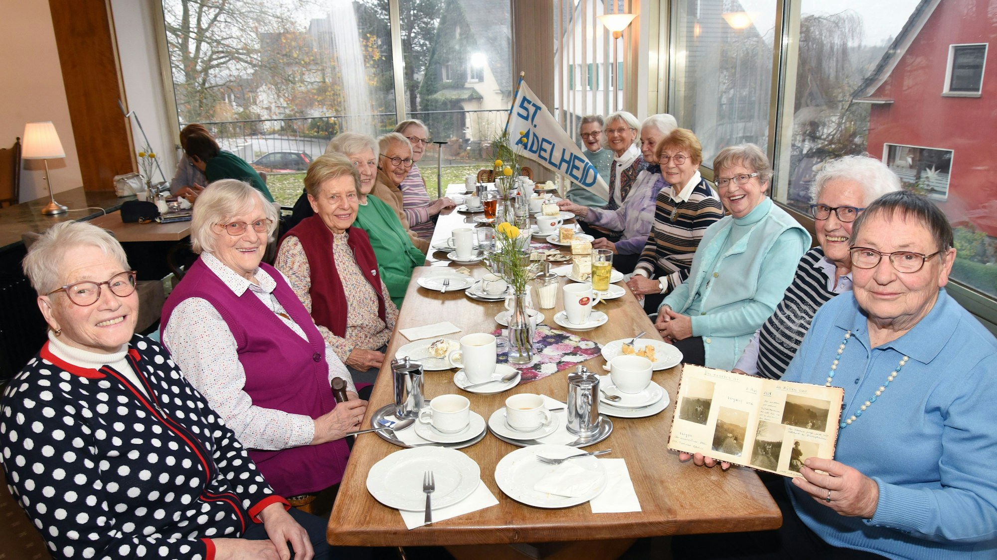 Das Foto zeigt freundlich lächelnde Damen an einer Kaffeetafel