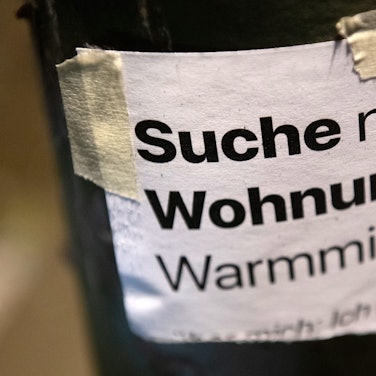 „Suche Wohnung“ steht auf einem Zettel an einer Laterne.