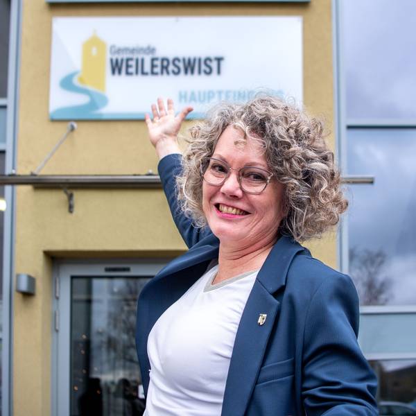 Bürgermeisterin Anne Horst zeigt auf das neue Schild am Rathaus.