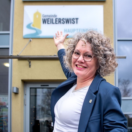 Bürgermeisterin Anne Horst zeigt auf das neue Schild am Rathaus.