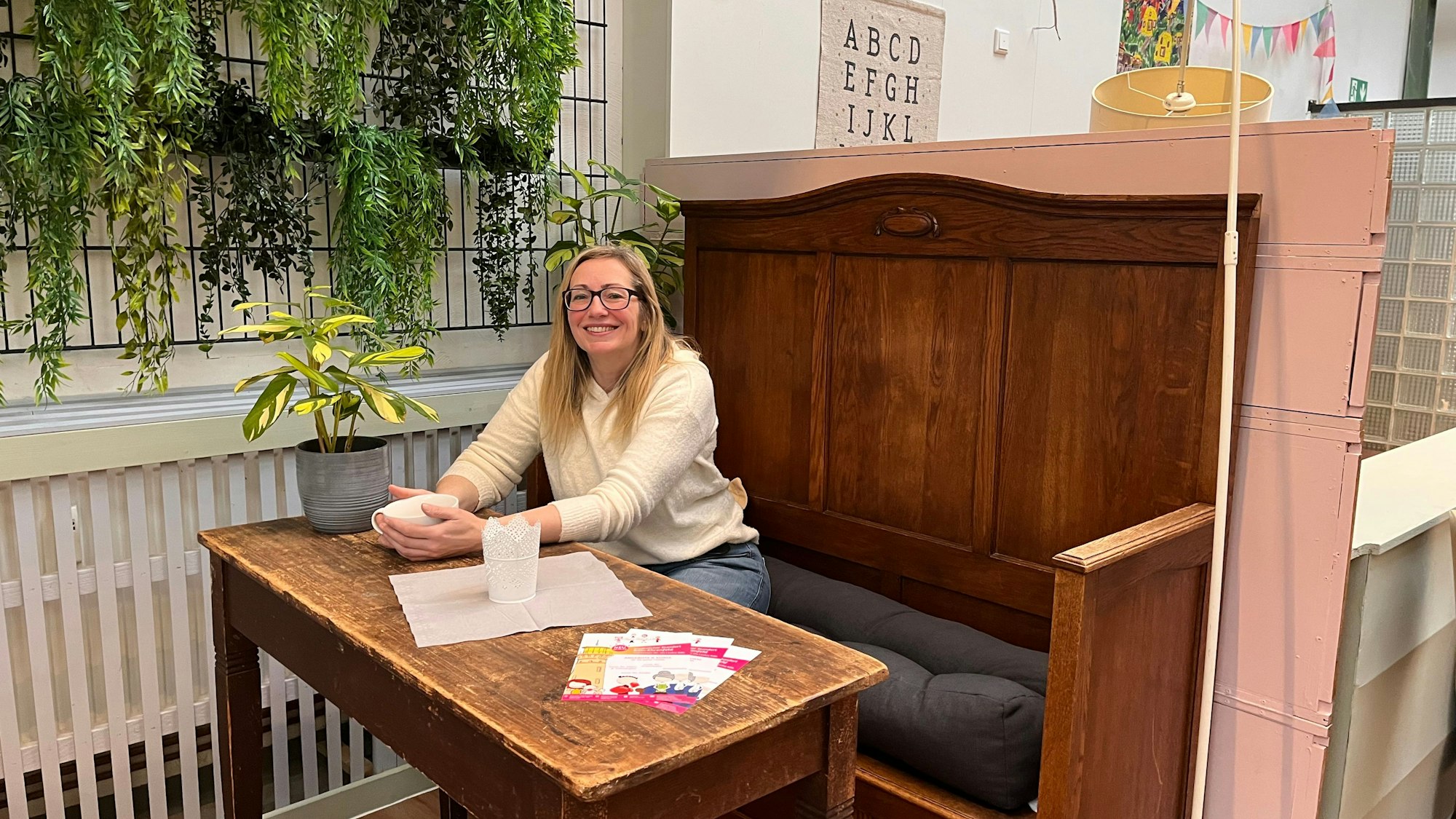 Astrid Heinen, Gründerin von Tante Astrid, sitzt an einem Tisch in den Räumlichkeiten des neuen Standorts in Köln-Ehrenfeld.