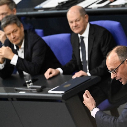 Friedrich Merz (vorne) hält seine Rede im Bundestag, im Hintergrund sind Finanzminister Christian Lindner, Wirtschaftsminister Robert Habeck und Bundeskanzler Olaf Scholz zu sehen (v. l. n. r.).