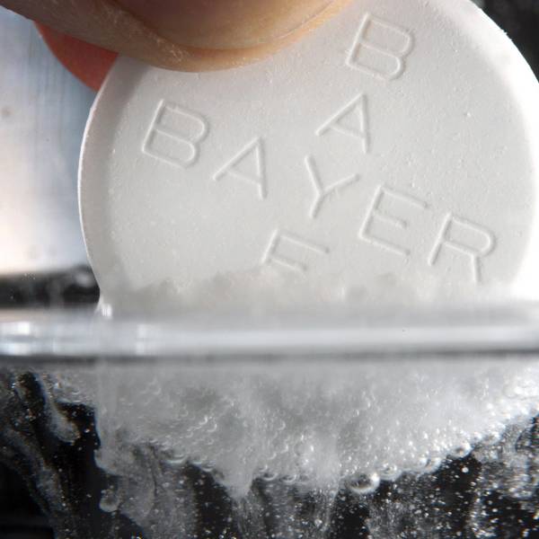 Eine Aspirin-Tablette des Bayer-Konzerns löst sich in einem Wasserglas auf.