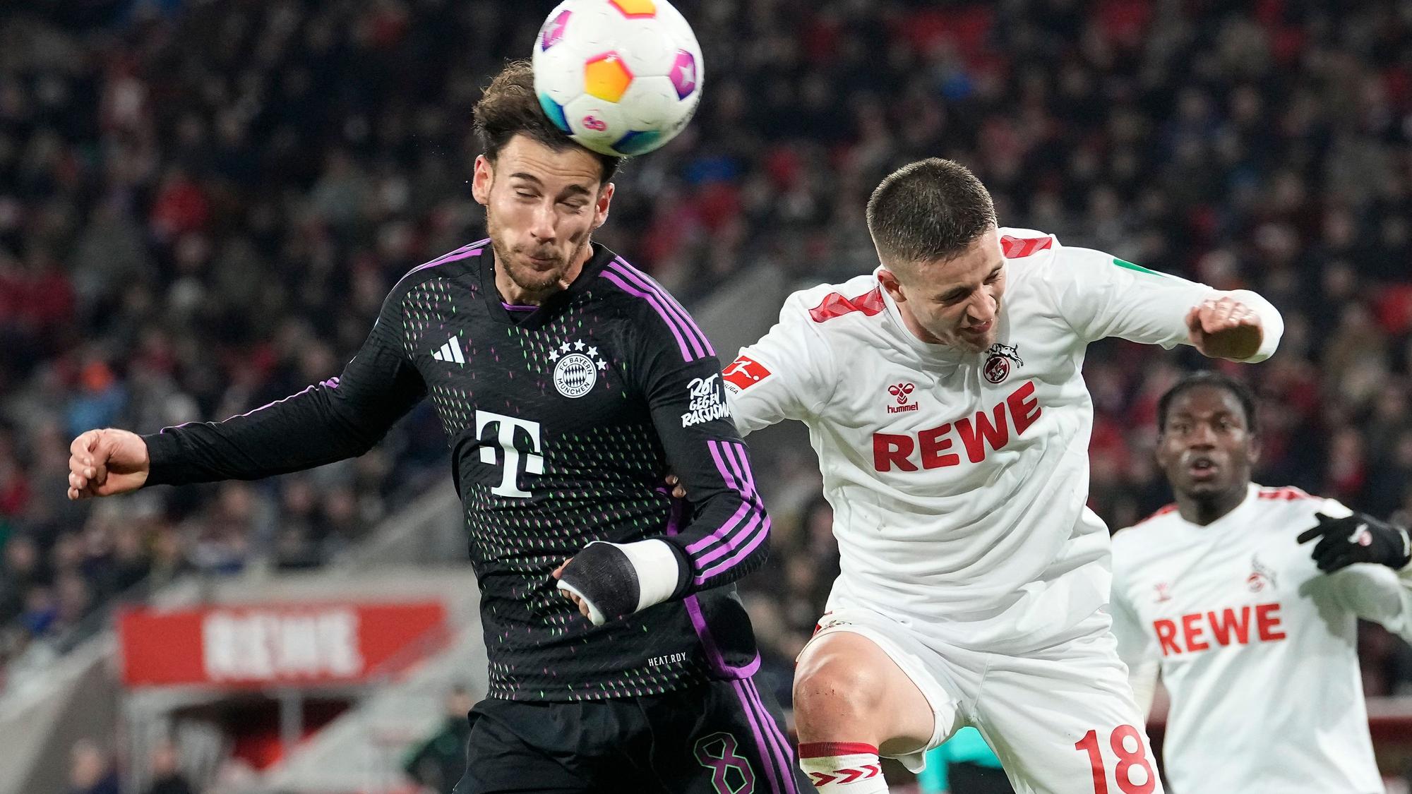 Kölns Rasmus Carstensen (r.)und Münchens Leon Goretzka springen zum Kopfball-Duell hoch.