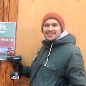 Vor einer Bude stehen zwei Männer.