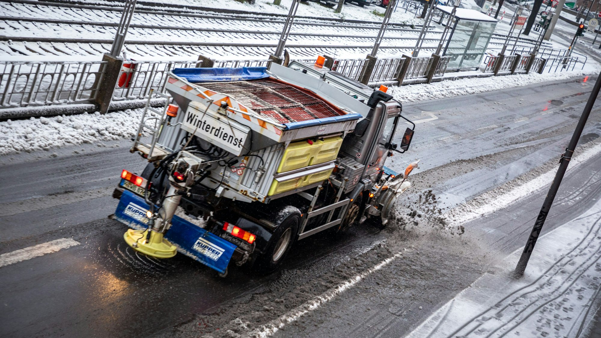 Ein mit einem Schneepflug ausgerüstet Fahrzeug der Abfallwirtschaftsbetriebe Köln (AWB) räumt 2021 mit seinem Räumschild Schnee und streut Streusalz auf der Straße „Sülzgürtel“. Nach Schneefall liegt in der Stadt eine dünne Schneedecke. Der nasse und schwere Schnee sorgt für matschige Straßen. (Symbolbild)
