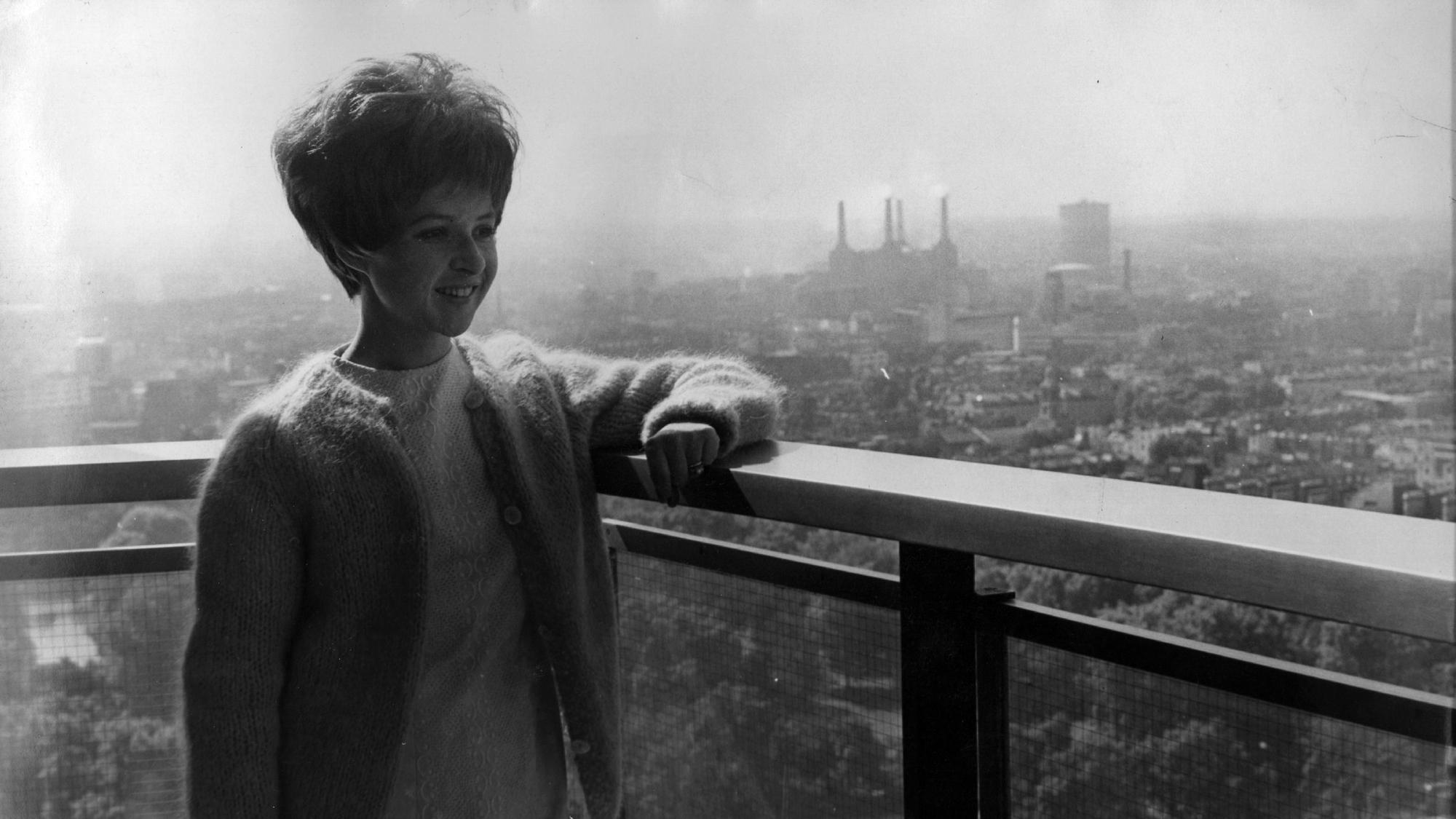 20th August 1964: American pop star Brenda Lee admires the view from her Hilton Hotel apartment during a trip to London for recording and TV appearances. Battersea power station can be seen in the distance. (Photo by Kent Gavin/Keystone/Getty Images)