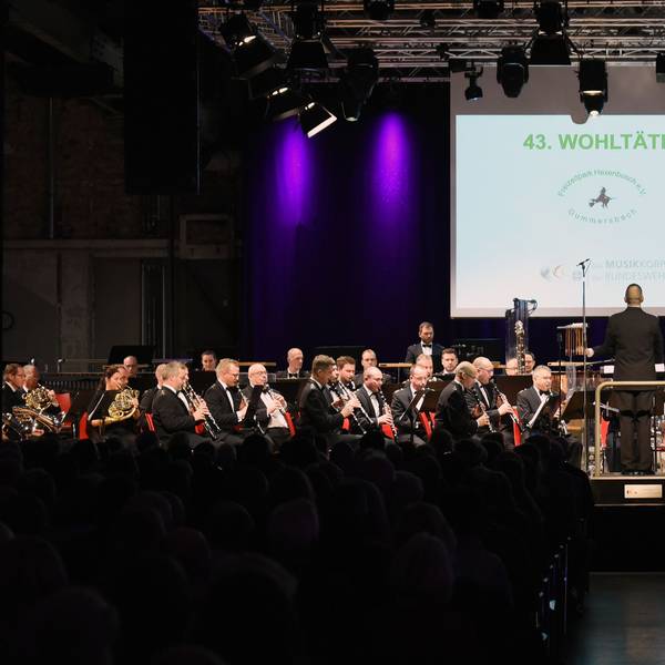 Ein Orchester spielt auf einer Bühne.