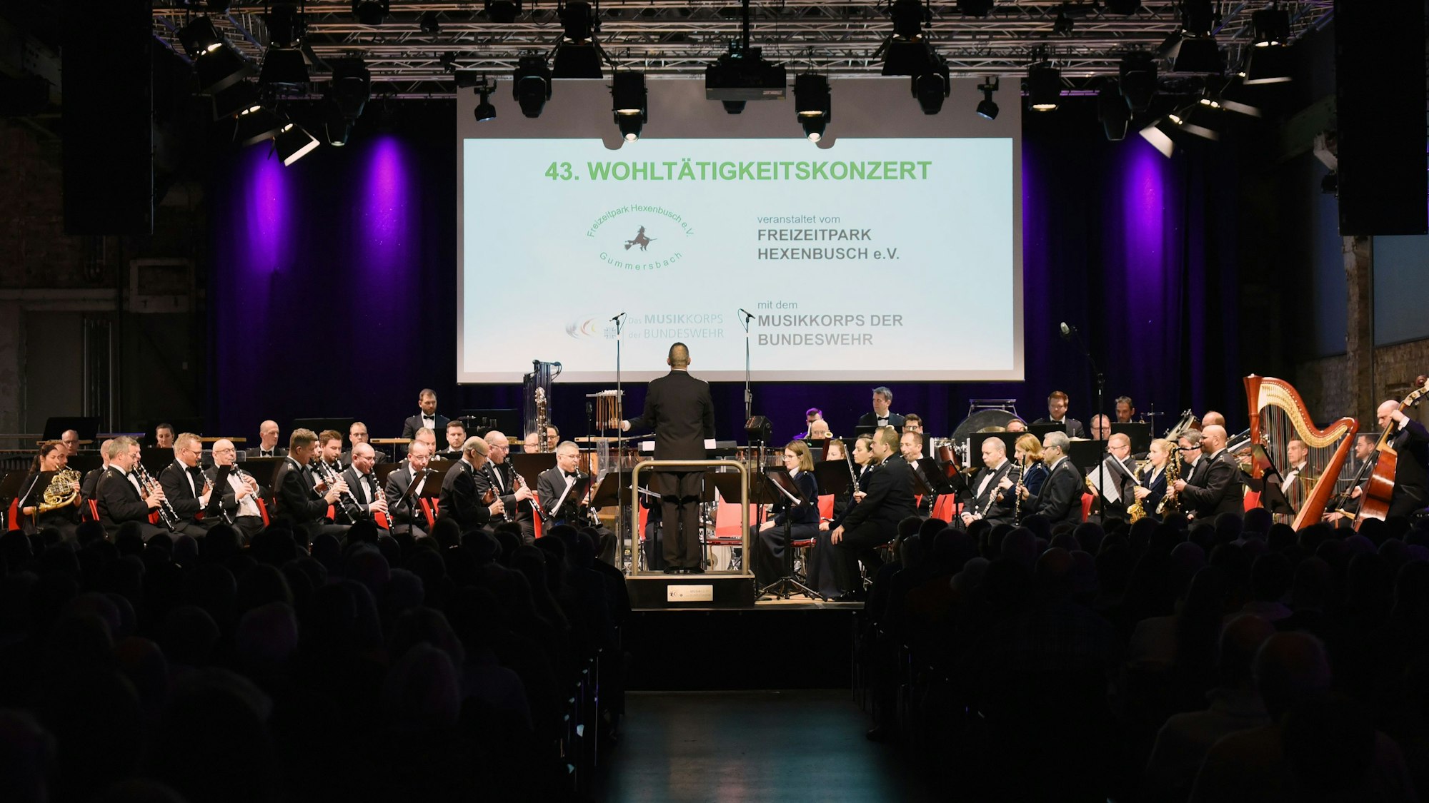 Ein Orchester spielt auf einer Bühne.