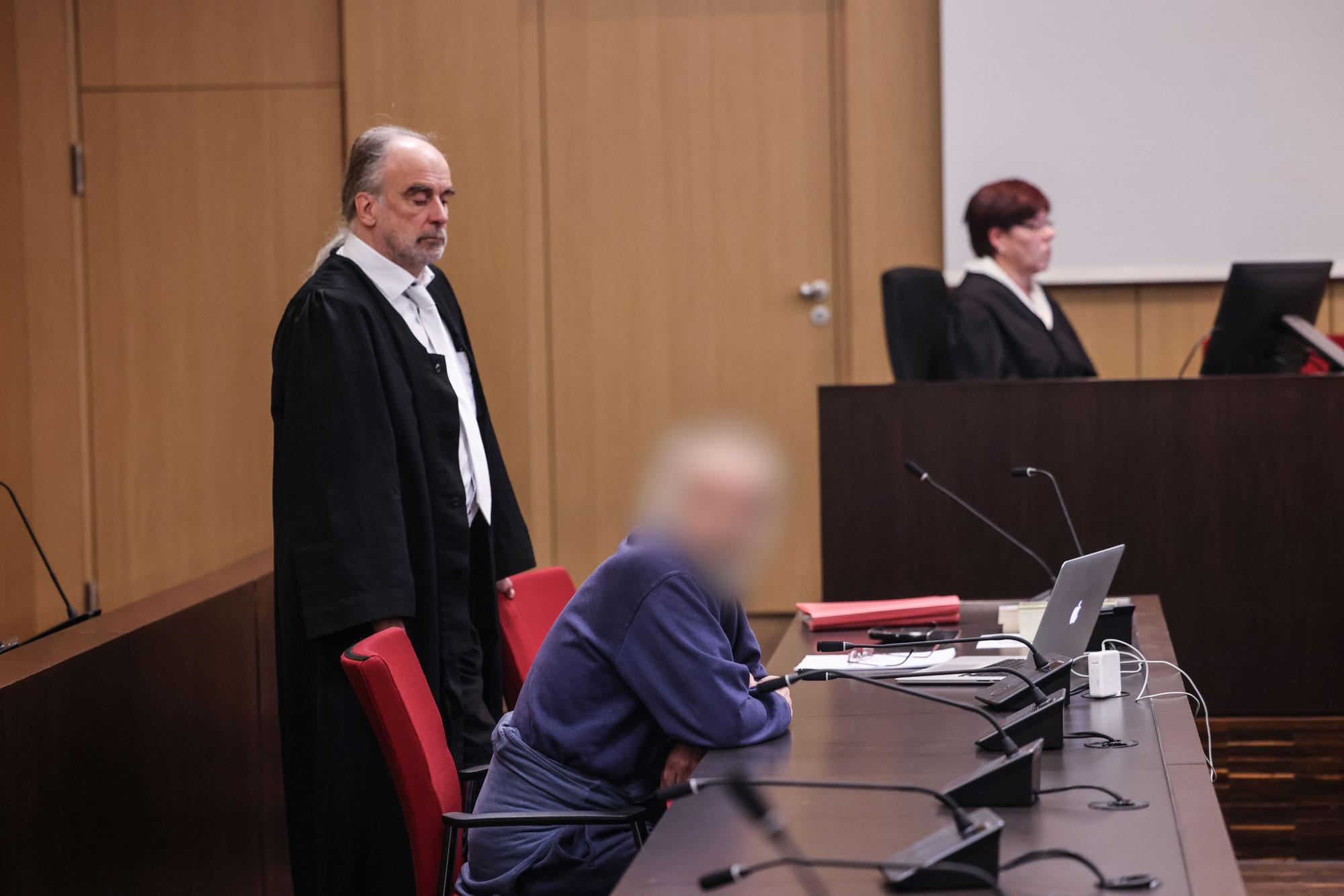 Der Angeklagte sitzt im Gerichtssaal neben seinem Anwalt Frank Schubert auf der Anklagebank. Wegen einer verheerenden Explosion in einem Hochhaus in Ratingen muss sich ein 57 Jahre alter Deutscher vor dem Landgericht Düsseldorf verantworten. Bei der Explosion vor sechs Monaten wurden mehrere Einsatzkräfte von Polizei, Feuerwehr und Rettungsdienst zum Teil schwer verletzt.
