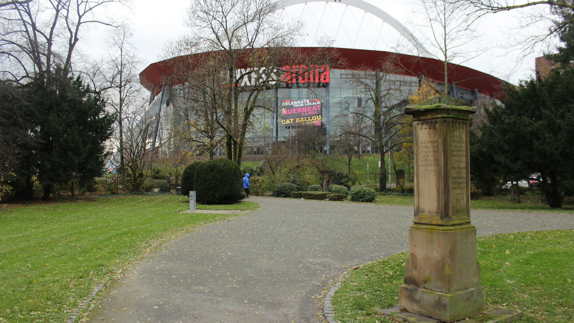 Parkanlage, im Hintergrund ein großes Glasgebäude