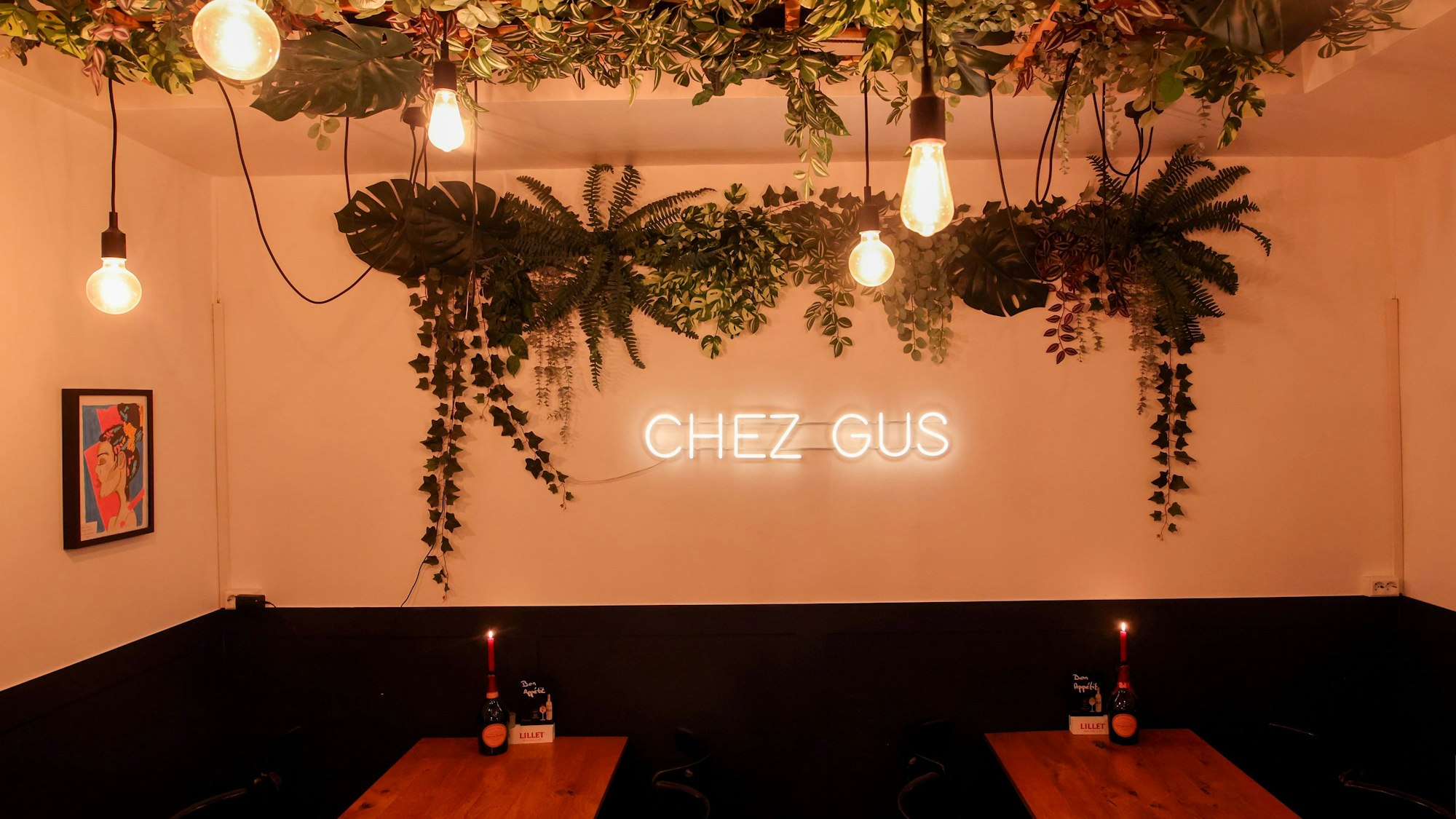 Gemütlicher Innenraum des Restaurants mit vielen Grünpflanzen.