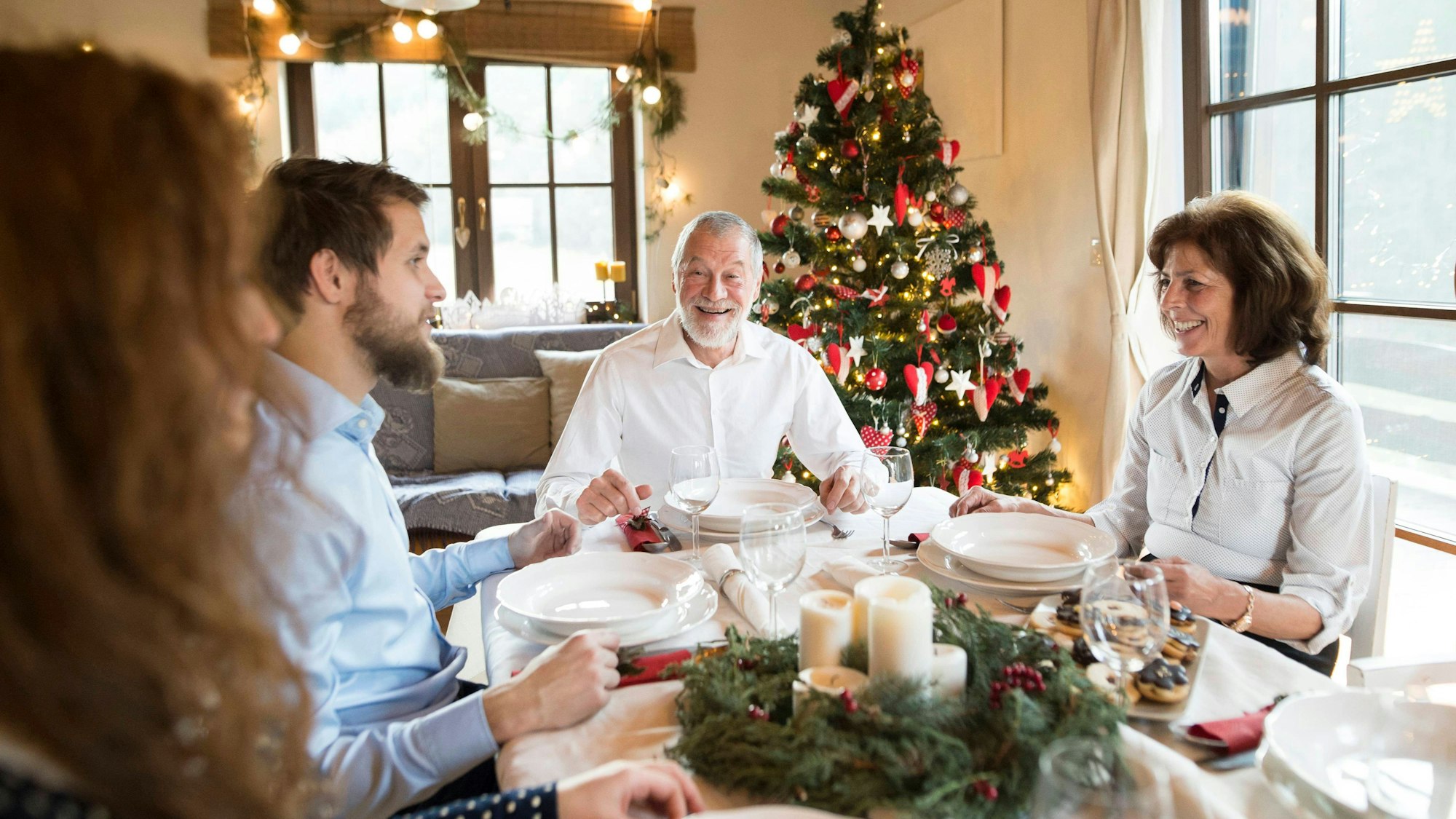 Eine Familie sitzt am gedeckten Tisch.
