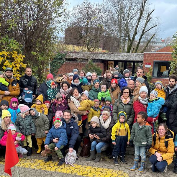 Eltern und Kinder stehen vor der städtischen Kindertagesstätte Weyertal.