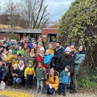 Eltern und Kinder stehen vor der städtischen Kindertagesstätte Weyertal.