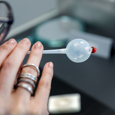 Eine Frau bläst in eine Glaskugel.