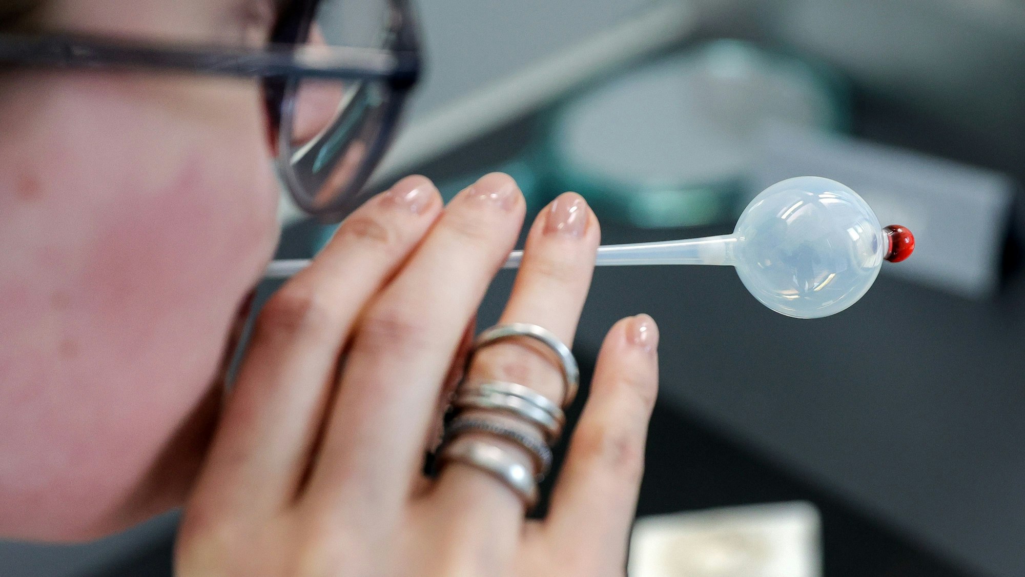 Eine Frau bläst in eine Glaskugel.