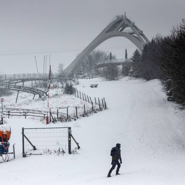27.11.2023, Nordrhein-Westfalen, Winterberg: Ein Mann spaziert in Winterberg vor der Sprungschanze entlang. Das nasskalte Wetter hält in Nordrhein-Westfalen an. Oberhalb von 300 bis 400 Metern hat es weitere Schneefälle gegeben, in tieferen Lagen Regen oder Schneeregen. (Zu dpa ·Nasskaltes Wetter in NRW hält an - Neuschnee in Höhenlagen·) Foto: Oliver Berg/dpa +++ dpa-Bildfunk +++