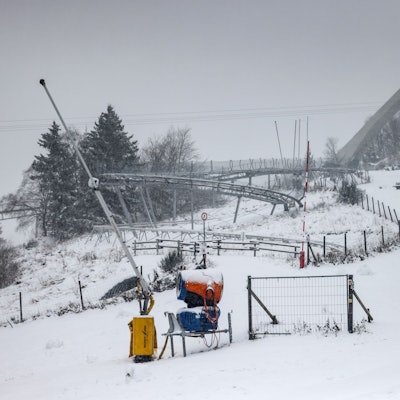 27.11.2023, Nordrhein-Westfalen, Winterberg: Ein Mann spaziert in Winterberg vor der Sprungschanze entlang. Das nasskalte Wetter hält in Nordrhein-Westfalen an. Oberhalb von 300 bis 400 Metern hat es weitere Schneefälle gegeben, in tieferen Lagen Regen oder Schneeregen. (Zu dpa ·Nasskaltes Wetter in NRW hält an - Neuschnee in Höhenlagen·) Foto: Oliver Berg/dpa +++ dpa-Bildfunk +++