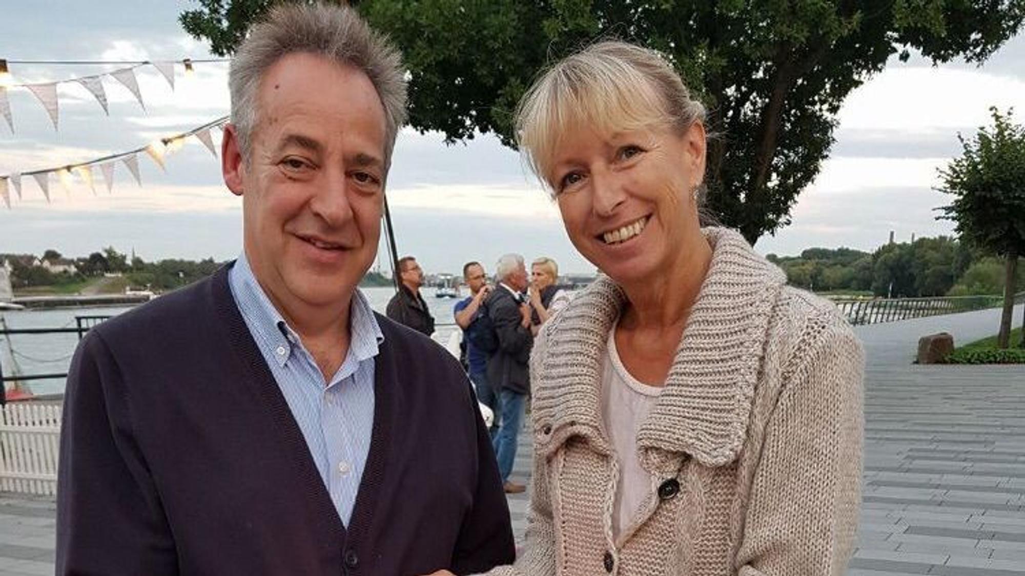 Ein Mann und eine Frau legen die Hände schützend um ein Licht.