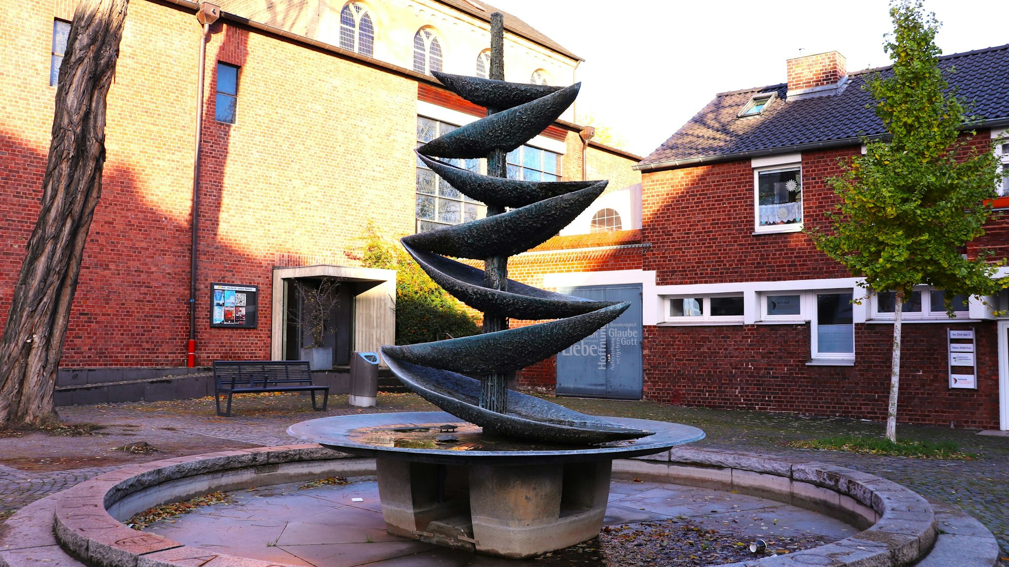Der Brunnen vor der Kirche St. Johann Baptist besteht aus Schalen, über die das Wasser im Zickzack plätschert.
