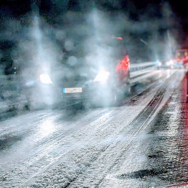 Auf einer Landstraße im Kreis Euskirchen fahren mehrere Autos bei Nacht über eine vereiste Straße. Am Straßenrand liegt Schnee. (Archivbild)