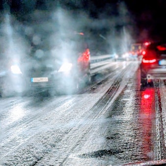 Auf einer Landstraße im Kreis Euskirchen fahren mehrere Autos bei Nacht über eine vereiste Straße. Am Straßenrand liegt Schnee. (Archivbild)
