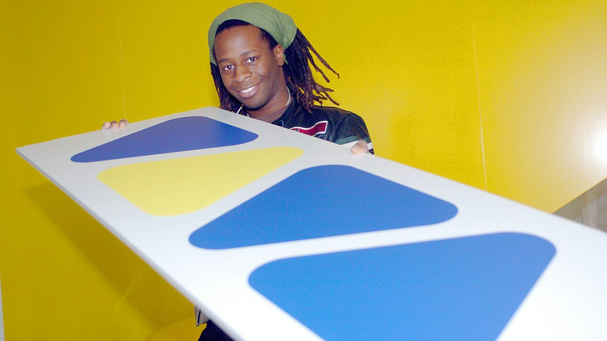 Mola Adebisi, ehemaliger Viva-Moderator, hält 2003 im Sendegebäude das bekannte Logo des Musiksenders in Händen. (Archivbild)