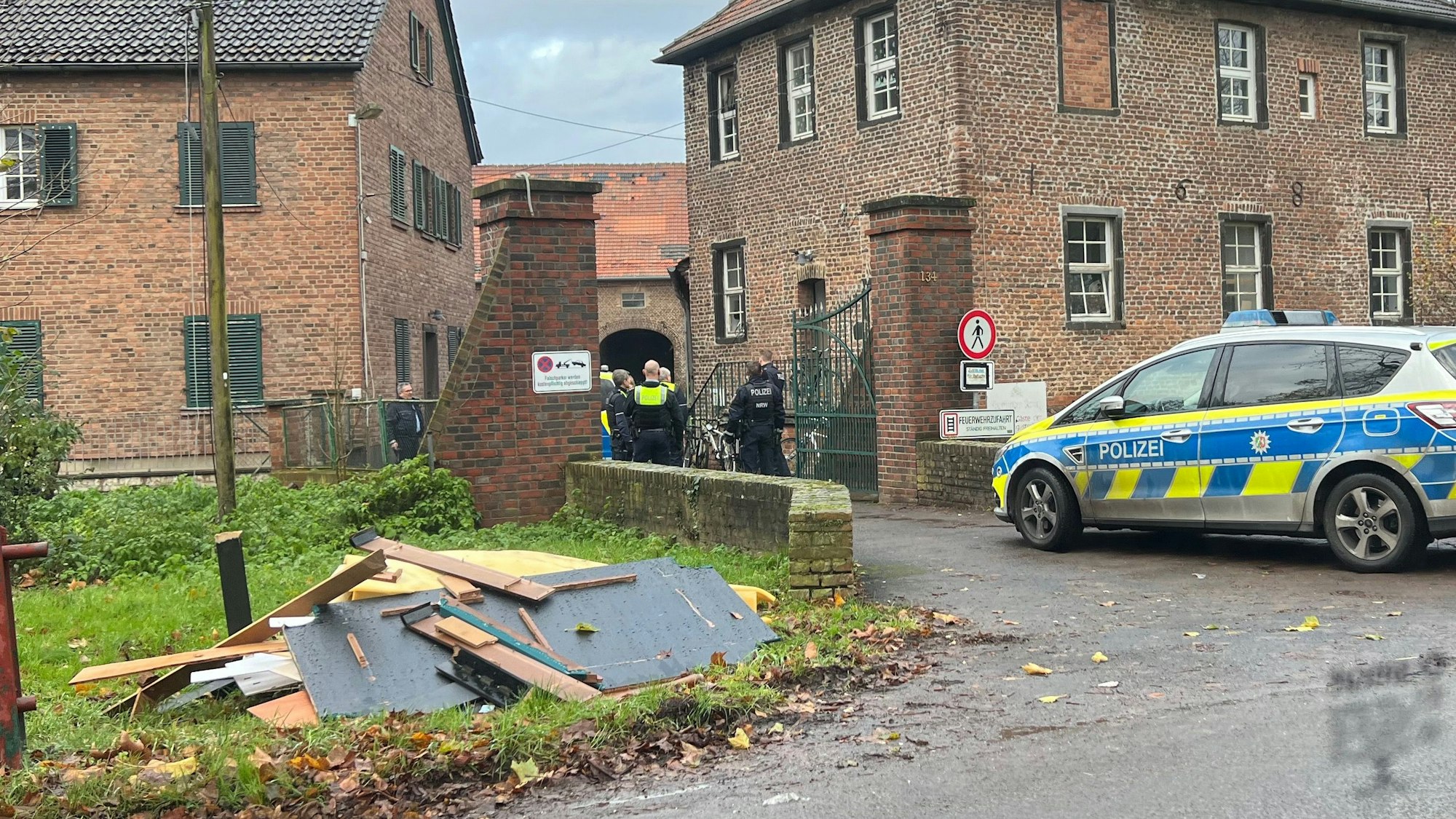Auf dem Hofe sind Polizeibeamte vor dem Eingang zum Dikopshof zu sehen.