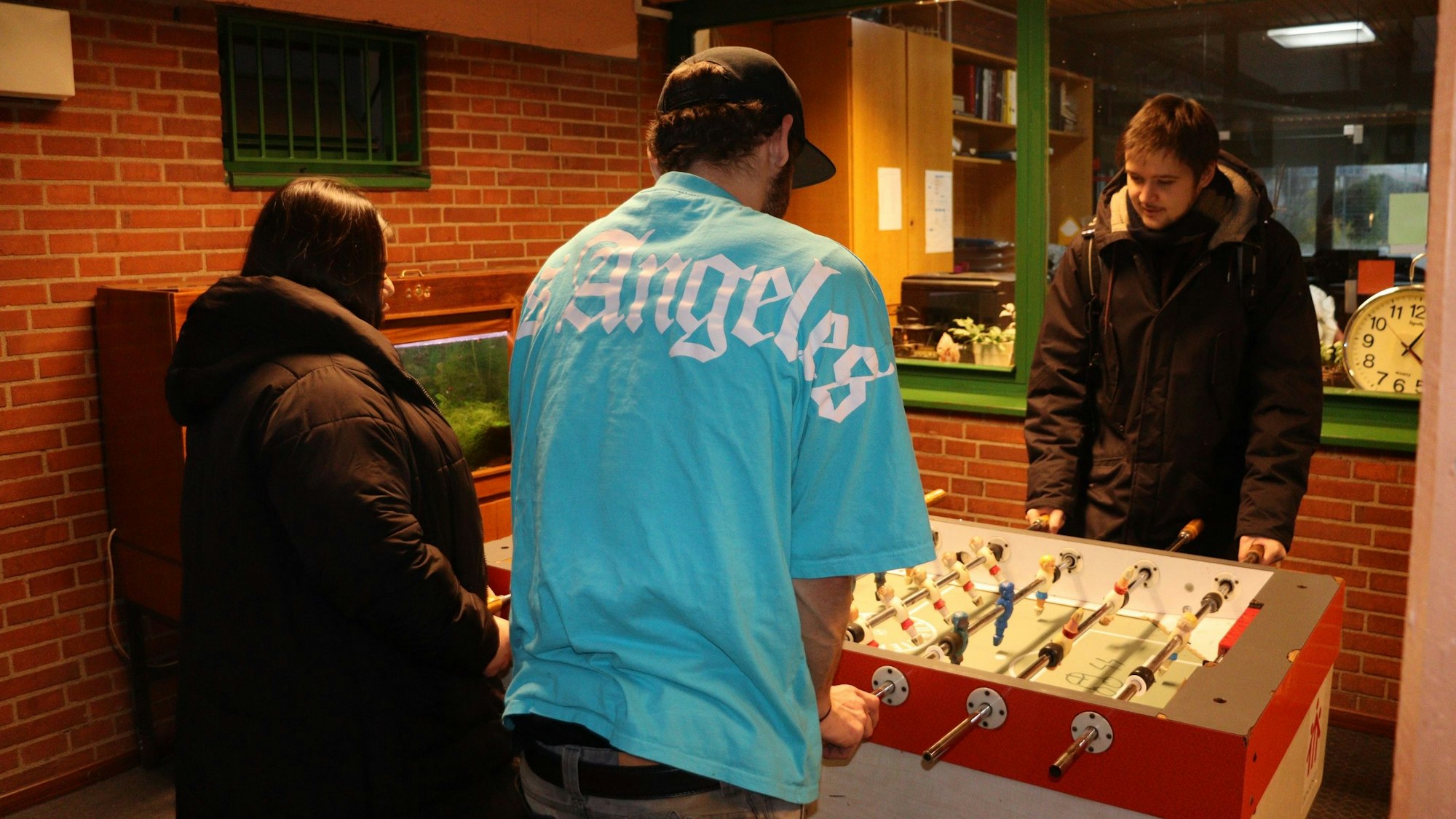 Sozialarbeiter Gereon Hostat (r.) spielt mit zwei betreuten Jugendlichen am Tischkicker.