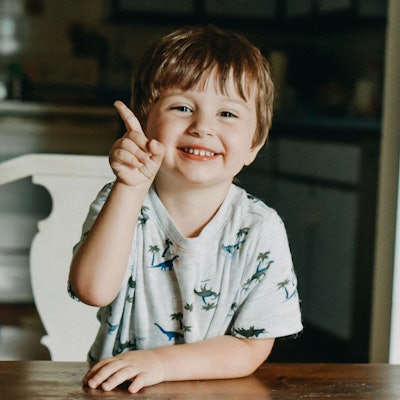 Ein kleiner Junge hebt den Zeigefinger.