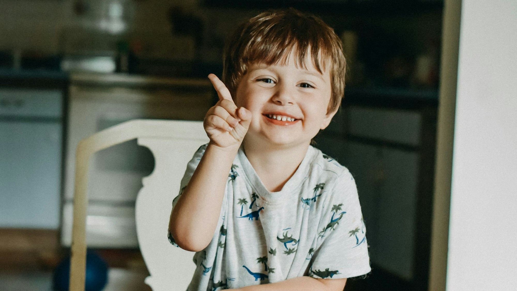 Ein kleiner Junge hebt den Zeigefinger.