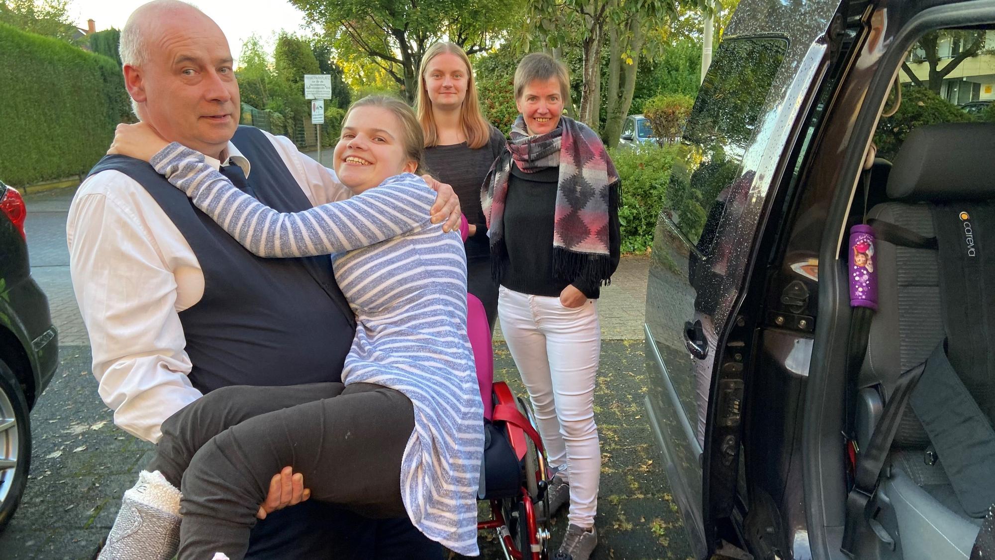 Auf dem Bild ist zu sehen, wie Laura in das jetzige Auto gehoben wird.