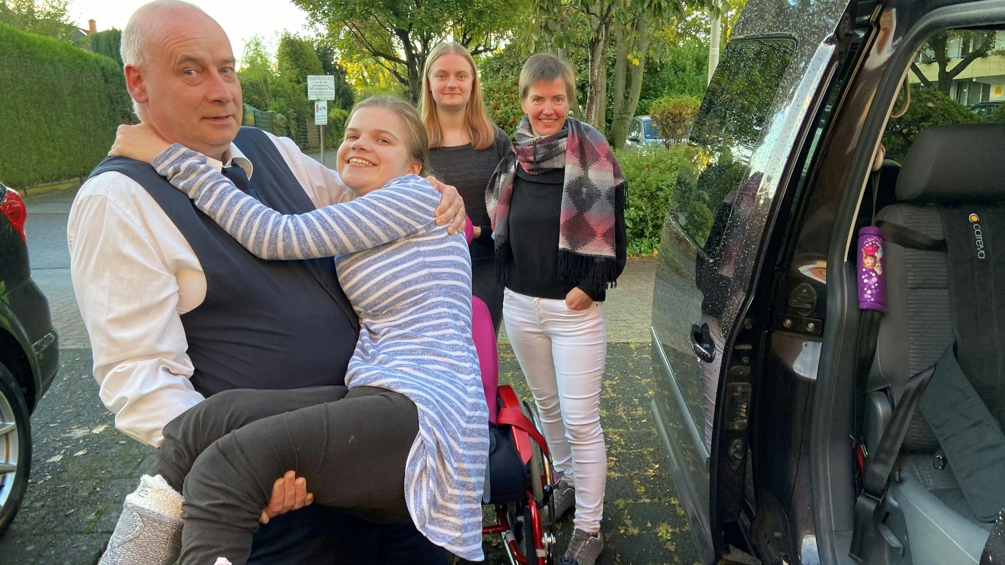 Auf dem Bild ist zu sehen, wie Laura in das jetzige Auto gehoben wird.