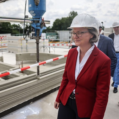 27.06.2023, Nordrhein-Westfalen, Nordkirchen: Ina Scharrenbach, (CDU), Ministerin für Heimat, Kommunales, Bau und Digitalisierung in Nordrhein-Westfalen, geht über die Baustelle von Europas erstem öffentlichen Gebäudes aus dem 3D-Drucker. Im Rahmen des Projekts «Digitalisierung der Bauwirtschaft und innovatives Bauen» wird das Vereinsheim des Sport-ClubCapelle digital gebaut. Der Druckbeton ist CO2-arm und voll recyclebar. Foto: Oliver Berg/dpa +++ dpa-Bildfunk +++