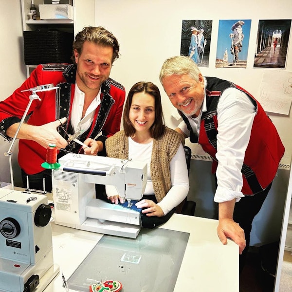 Alex Barth und Benjamin Weissert stehen neben Jasmin Engel, die an einer Nähmaschine sitzt.