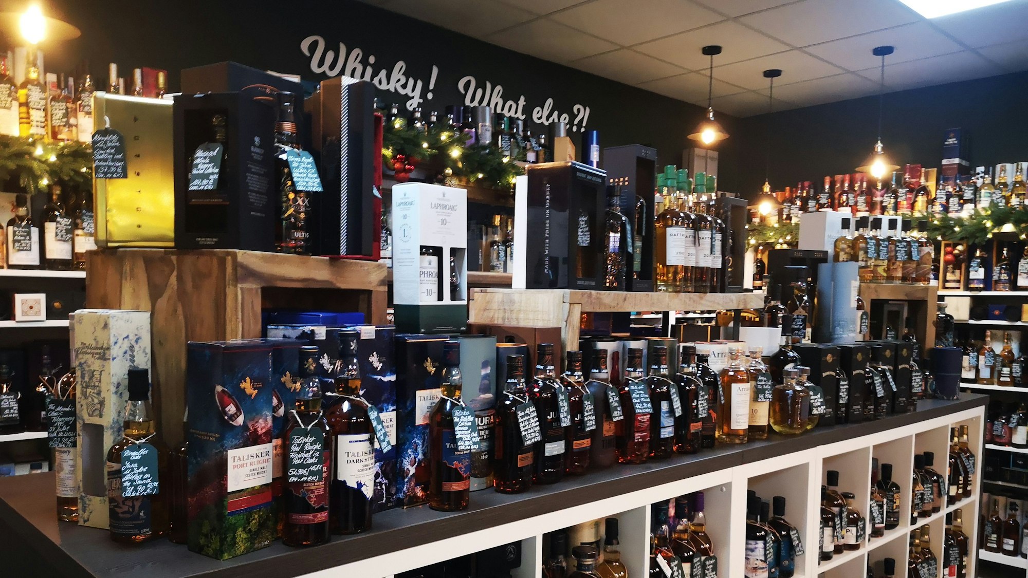 Auf halbhohen und mannshohen Wandregalen reihen sich Whiskyflaschen aneinander.