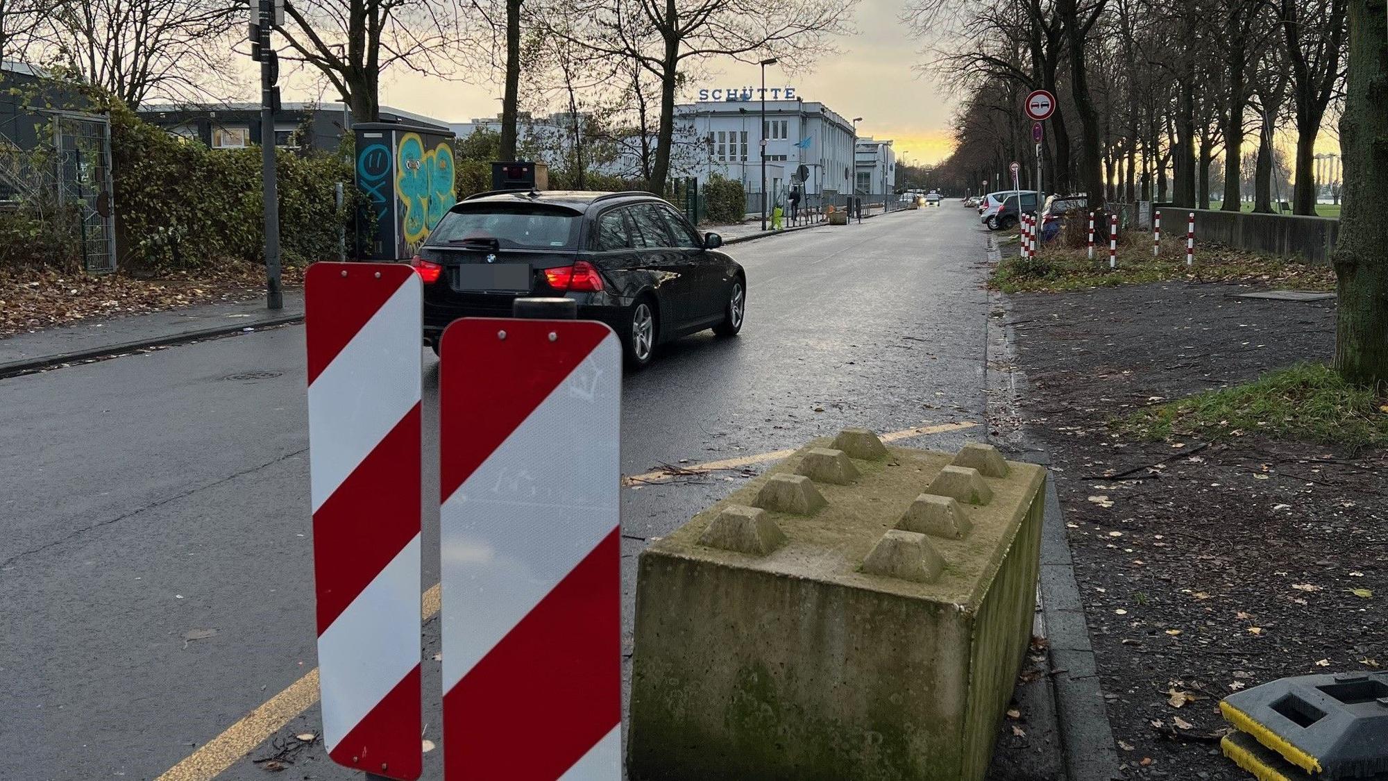 Ein Auto fährt an einer Warnbake auf der Alfred-Schütte-Allee vorbei.